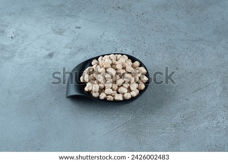 Raw pea beans in a black cup on the ground. High quality photo