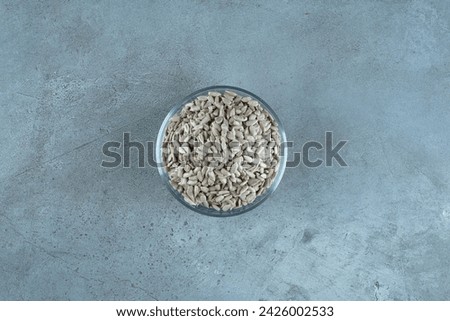 Sunflower seeds in a glass cup on blue background. High quality photo