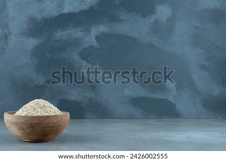 Wheat grains in a wooden cup on blue background. High quality photo