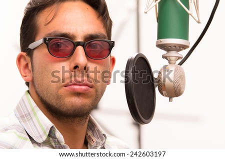 handsome brunette man singing in music studio