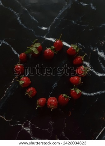 This picture is about strawberries with a black marble background. This fruit is an antioxidant which is very beneficial for health because it contains vitamin C