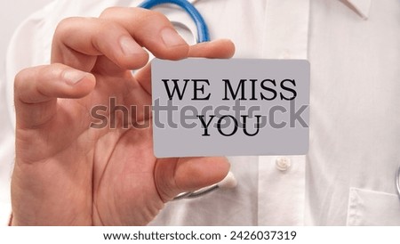 we miss you text written on a white card in the hands of a businessman