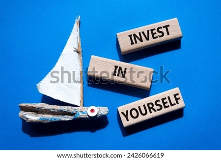 Invest in Yourself symbol. Concept words Invest in Yourself on wooden blocks. Beautiful blue background with boat. Business and Invest in Yourself concept. Copy space.