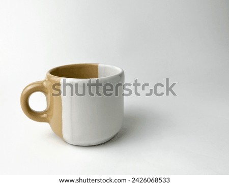 Two tone white and brown colored ceramic porcelain tea or coffee cup drinking table ware. Object photography isolated on white studio background.