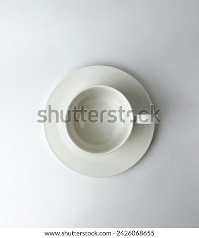 Classic white colored tea or coffee cup drinking table ware with handle and plate. Object photography isolated on white studio background.