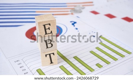 EBT word written on wood block. EBT - Electronic Benefit Transfer - word is made of wooden building blocks with economic graphic Business, economic concept, white background