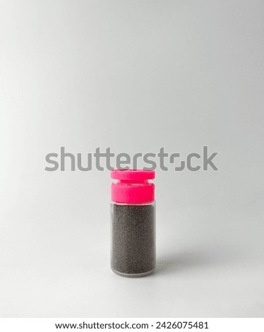 Small micro natural pet fish food inside plastic bottle packaging with pink colored lid. Object photography isolated on white background.