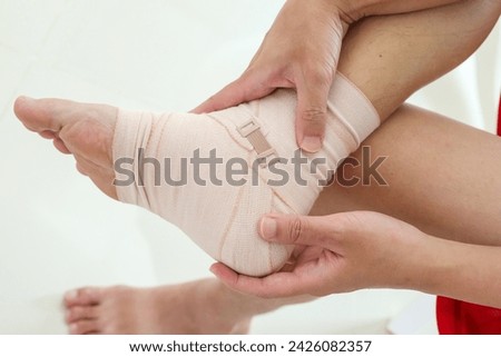 Man with ankle sprain elastic bandage for ankle injury and feeling pain Royalty-Free Stock Photo #2426082357