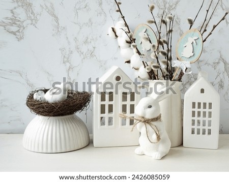 Easter composition on a light background. Cute white rabbits, willow twigs, Easter eggs symbol of the Easter holiday. Home and office decoration. The bright holiday of Easter.