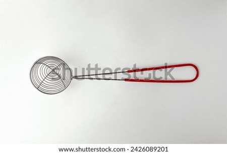 Small round spiral strainer with rubber handle. Cooking kitchen utensil tools isolated object photography on white studio background. Royalty-Free Stock Photo #2426089201