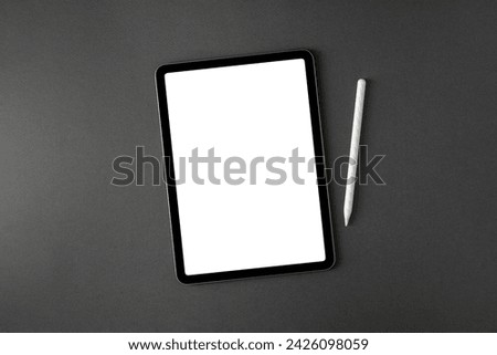 Tablet with blank screen and stylus on dark gray office desk Royalty-Free Stock Photo #2426098059