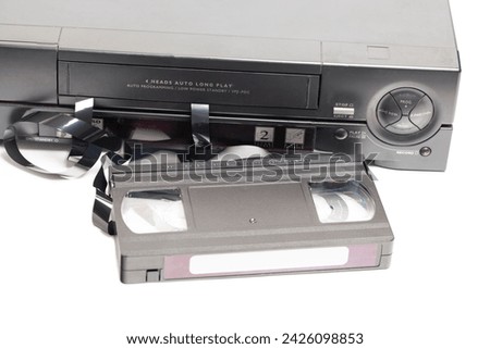 Retro video cassette recorder with VHS cassette with unwound tape isolated on white background. Royalty-Free Stock Photo #2426098853