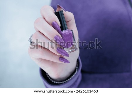 Female hands with long nails and purple manicure 