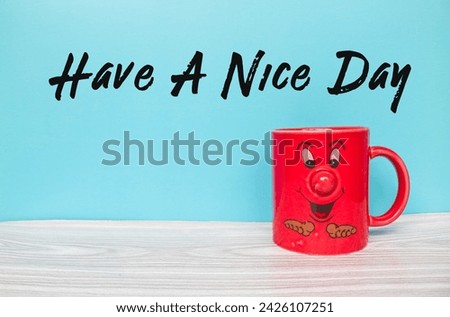 the words Have A Nice Day and red coffee cup with cartoon face emoji isolated with blue background