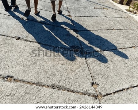 Shadow of three walking people