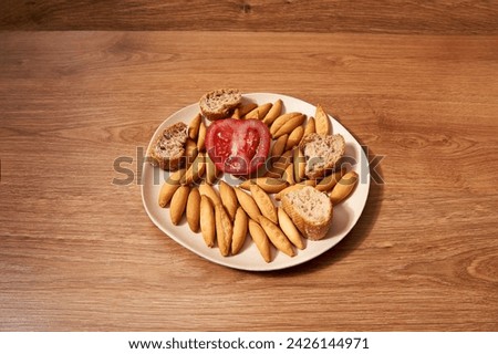 plate with micro rolls called picos, pieces of bread with seeds and half a tomato