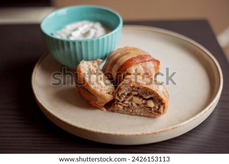 savory delight: delicious dish with meatballs wrapped in bacon, filled with mozzarella and yogurt sauce