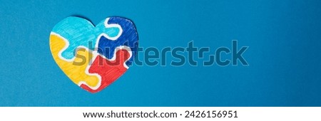Banner. Colorful puzzle heart on blue background. Multi-colored heart as a symbol of World Autism Awareness Day