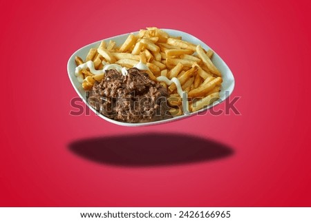 Floating plate with Flamish stew and french fries  on red gradient background Royalty-Free Stock Photo #2426166965