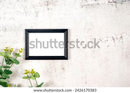 Picture frame mockup with eucalyptus branches on grey concrete background, Blank mockup for artwork, print or photo presentation.