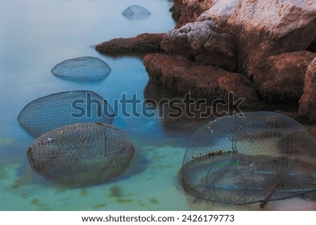 Metal fishing cages left with bait to catch fishes Royalty-Free Stock Photo #2426179773