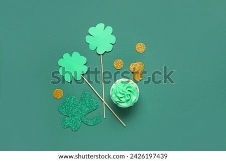 Tasty cupcake with decor for St. Patrick's Day on green background