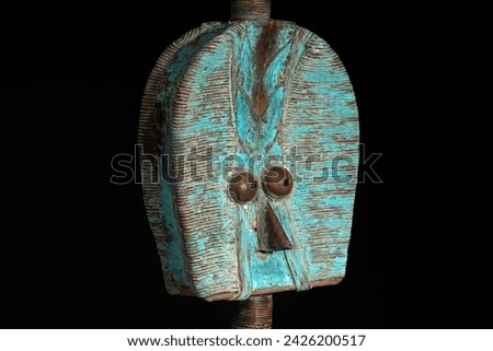 Close up of a wooden Kota reliquary figure from Gabon, isolated on a black background. Tribal African art, showcasing masterful craftsmanship and spiritual symbolism. Royalty-Free Stock Photo #2426200517