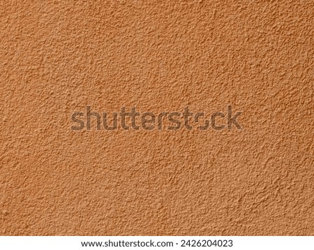 Textured plaster on a wall in the color orange, texture background