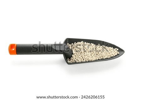 Gardening shovel with granular fertilizer isolated on white background Royalty-Free Stock Photo #2426206155