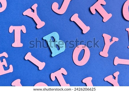 One blue letter among pink ones on color background. Concept of uniqueness