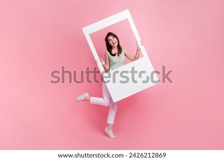 Full length photo of lovely cute girl wear trendy clothes hold social media picture avatar isolated on pink color background