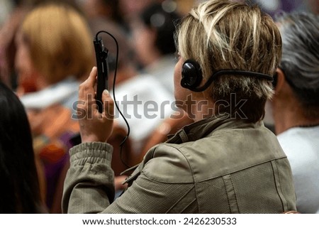 a set of headphones for simultaneous translation during negotiations in foreign languages. woman headphones used for simultaneous translation equipment simultaneous interpretation	 Royalty-Free Stock Photo #2426230533