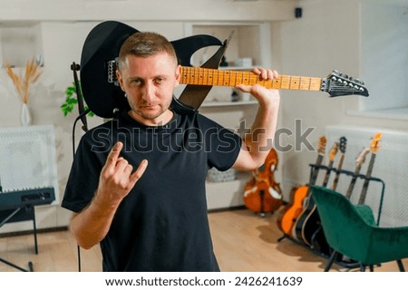 portrait of a brutal rock performer with an electric guitar in a recording studio before a performance rehearsal