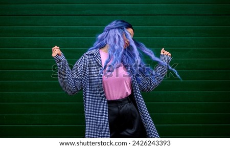 Happy woman dancing. Girl dancer with creative colored hair and hairstyle. Lifestyle photo. Cosplay on an anime character.
