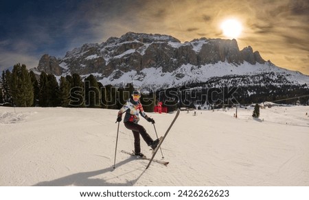 Young woman with raised leg enjoying a ski resort around Sela mountain, Selaronda, Dolomites, Italy Royalty-Free Stock Photo #2426262623
