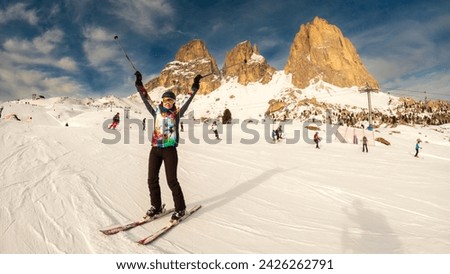 Young woman with raised arms enjoying a ski resort around Sela mountain, Selaronda, Dolomites, Italy Royalty-Free Stock Photo #2426262791