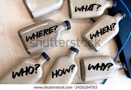 Word text where, when, who, what, why, how questions - uncertainty, brainstorming or decision making concept, written on a brown bottle and brown table as background with network cable. Royalty-Free Stock Photo #2426264763