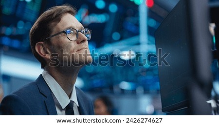 Portrait of an Adult Working in International Stock Exchange Company: Professional Using Computer with Multiple Screens, Monitoring Financial Markets, Communicating with Business Partners. Royalty-Free Stock Photo #2426274627