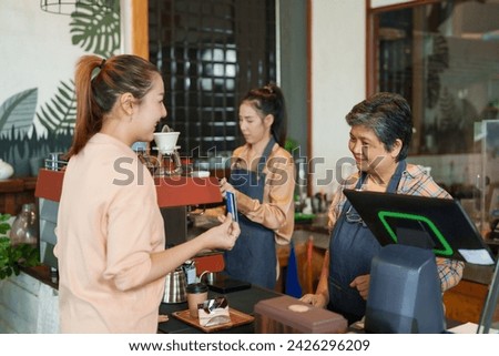Businessman shop owner elderly Asian retired pensioner employee cafe small business smiling customer holding credit card pay  cash register daughter making coffee Family business shop minimalist style
