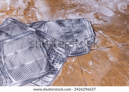 car foot mats washing with soap at car wash station's floor