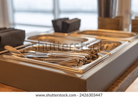 Cutlery tray in a café, Buffet Food Cutlery Tray. Knives, forks, spoons in a cutlery organizer. Eco-Friendly metal utensils. Sustainability concept Royalty-Free Stock Photo #2426303447