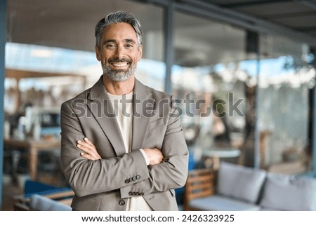 Happy middle aged business man entrepreneur looking at camera outdoors. Smiling confident mature businessman professional executive, successful lawyer wearing suit standing arms crossed, portrait. Royalty-Free Stock Photo #2426323925