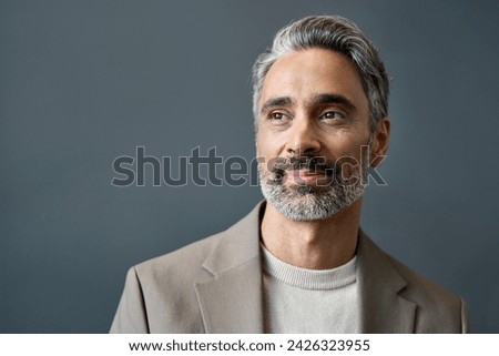 Middle aged business man looking away thinking of future ideas. Smiling confident older mature professional businessman executive ceo manager or entrepreneur standing at gray background. Portrait. Royalty-Free Stock Photo #2426323955
