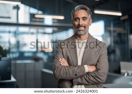 Happy middle aged older professional business man, smiling mature executive ceo manager, mature male entrepreneur, rich confident business owner standing in office looking at camera, portrait. Royalty-Free Stock Photo #2426324001