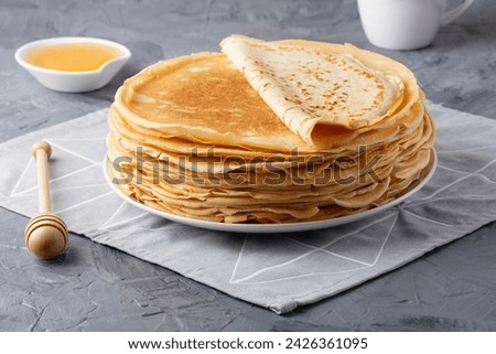 Stack of traditional russian pancakes blini on gray background with copy space. Homemade russian thin pancakes blini. Russian food, russian kitchen Royalty-Free Stock Photo #2426361095