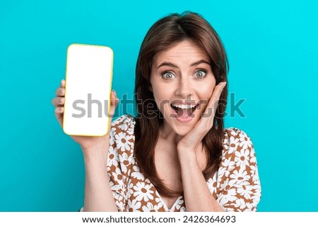 Photo of young impressed lady touch cheek shock emotions promoting copyspace smartphone social media isolated on cyan color background