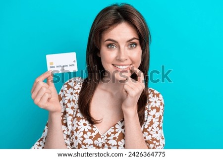 Closeup photo of cheerful woman advertising white credit card touch teeth admire do more purchases isolated on cyan color background