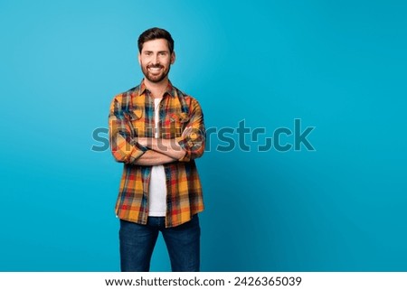 Photo of attractive young man folded hands confident entrepreneur dressed stylish checkered clothes isolated on blue color background