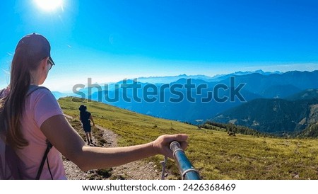 Couple with baby carrier on hiking trail with scenic view of magical mountain peaks Karawanks and Julian Alps seen from Goldeck, Latschur group, Gailtal Alps, Carintha, Austria. Austrian Alps summer Royalty-Free Stock Photo #2426368469