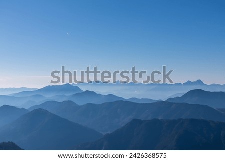 Panoramic view of magical mountain peaks of Karawanks and Julian Alps seen from Goldeck, Latschur group, Gailtal Alps, Carinthia, Austria, EU. Mystical atmosphere in Austrian Alps on sunny summer day. Royalty-Free Stock Photo #2426368575